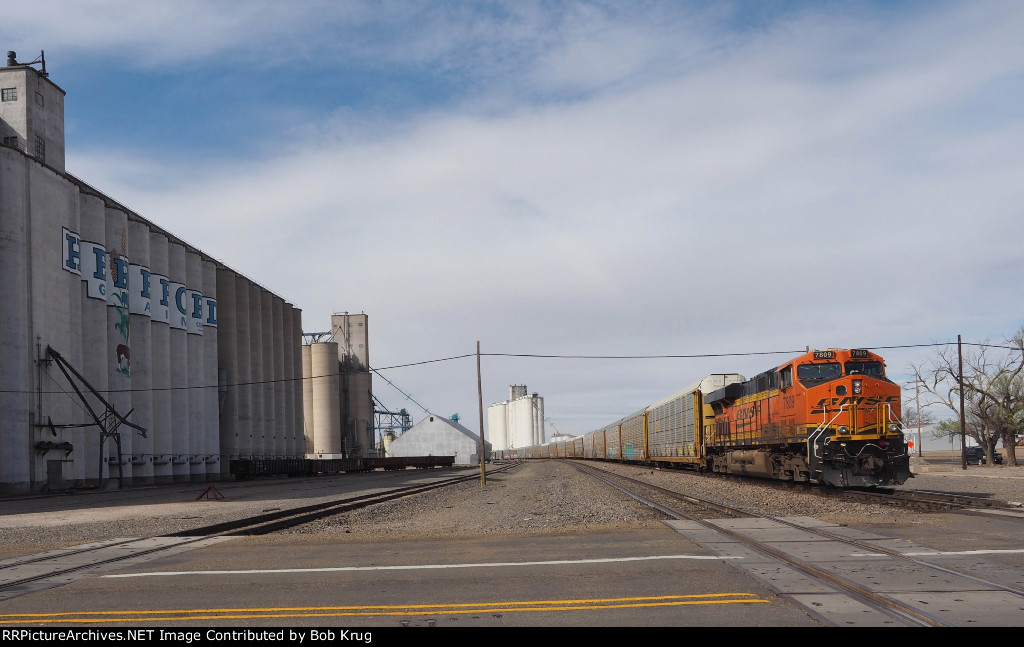 BNSF 7809 is pushing a westbound autorack train past the grain elevators in Hereford, TX